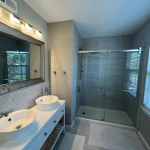 Eco-friendly house cleaning Harford County bathroom with clean shower glass, vanity, sink, and polished floor by LuxeGlow EcoClean