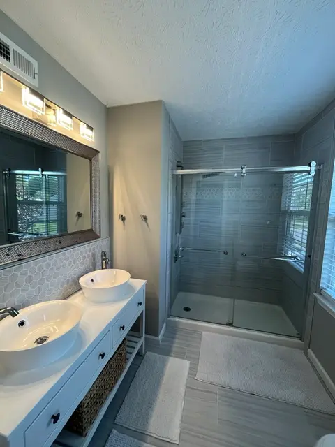 Eco-friendly house cleaning Harford County bathroom with clean shower glass, vanity, sink, and polished floor by LuxeGlow EcoClean